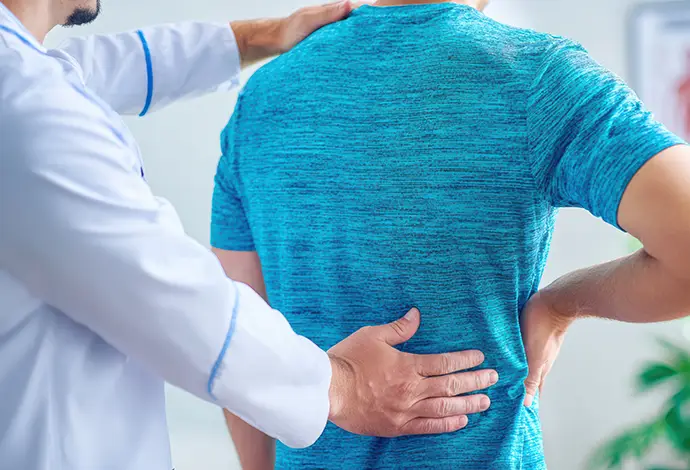Doctor examining a patient with back pain in a medical office
