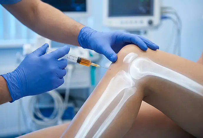 Medical professional administering a hyaluronic acid injection into a patient’s knee to help relieve joint pain and improve mobility in St. Peters MO