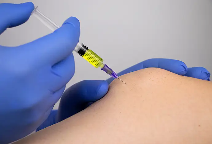 orthopedic surgeon gives an injection in the knee