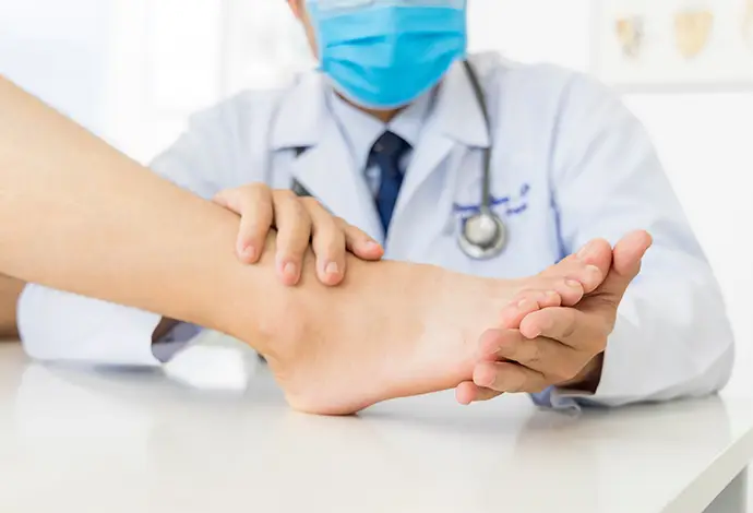 orthopedic doctor or surgeon in white gown examined the patient with foot pain problem
